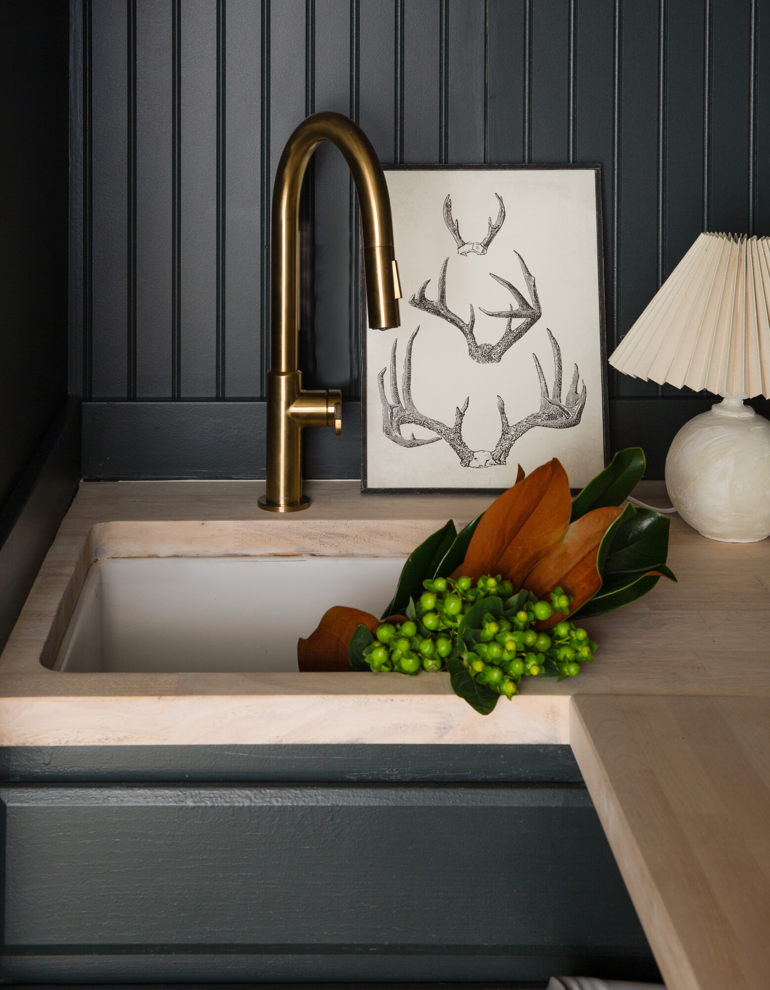 Moody laundry room in Farrow & Ball "Studio Green" and butcher block countertops