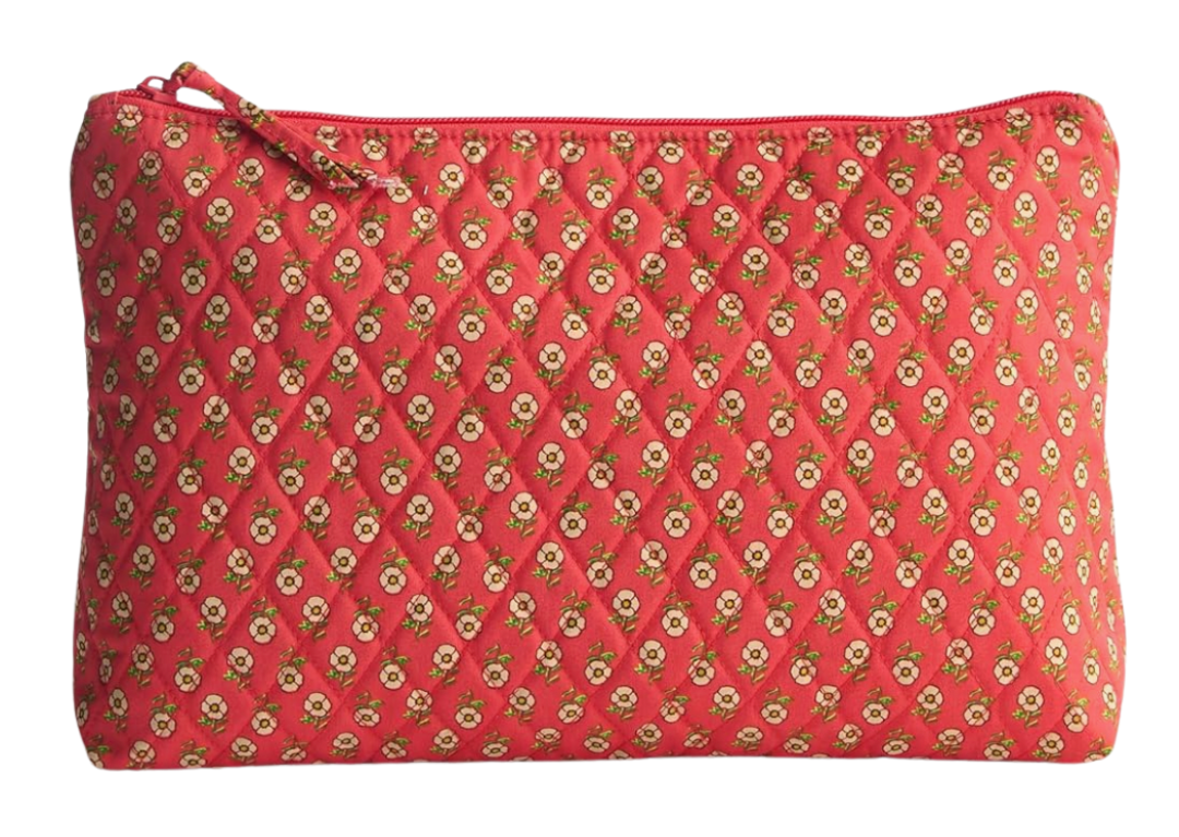 A soft zippered pouch with red quilted fabric featuring a repeating floral print in beige and green.