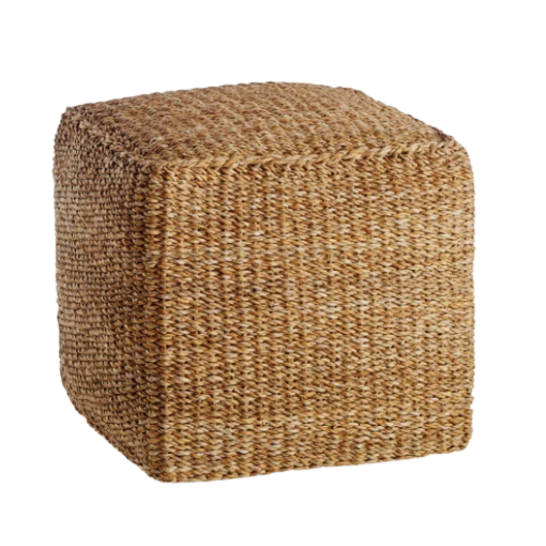 Square woven seagrass pouf with a natural texture and warm honey tones, perfect for use as an outdoor footrest, extra seating, or a casual side table on a patio or porch.