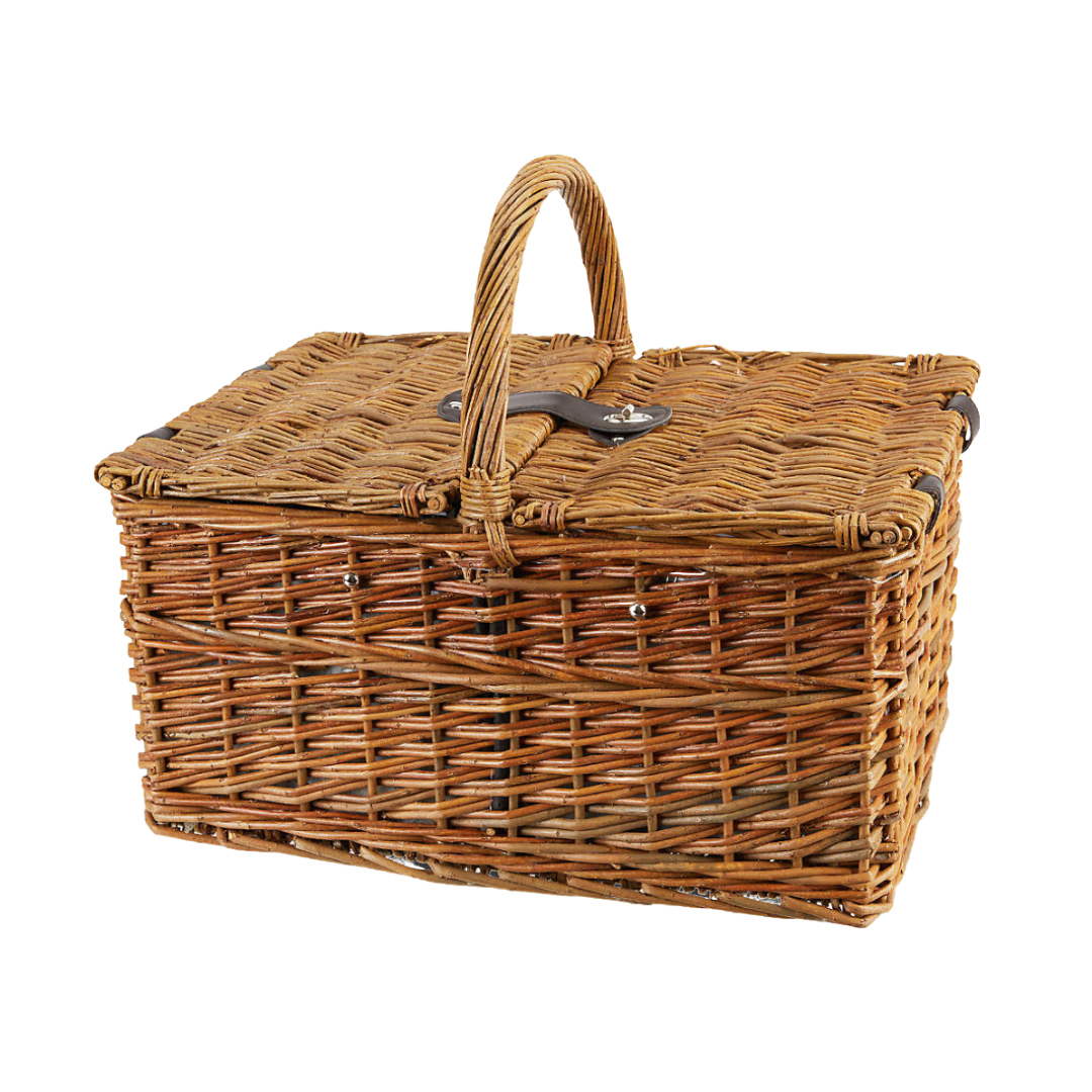 A classic rectangular woven wicker picnic basket with a top handle and dual flip-lid closure secured by a leather strap and metal clasp. The basket features a tight weave with a warm honey-brown finish, perfect for outdoor gatherings or charming storage.