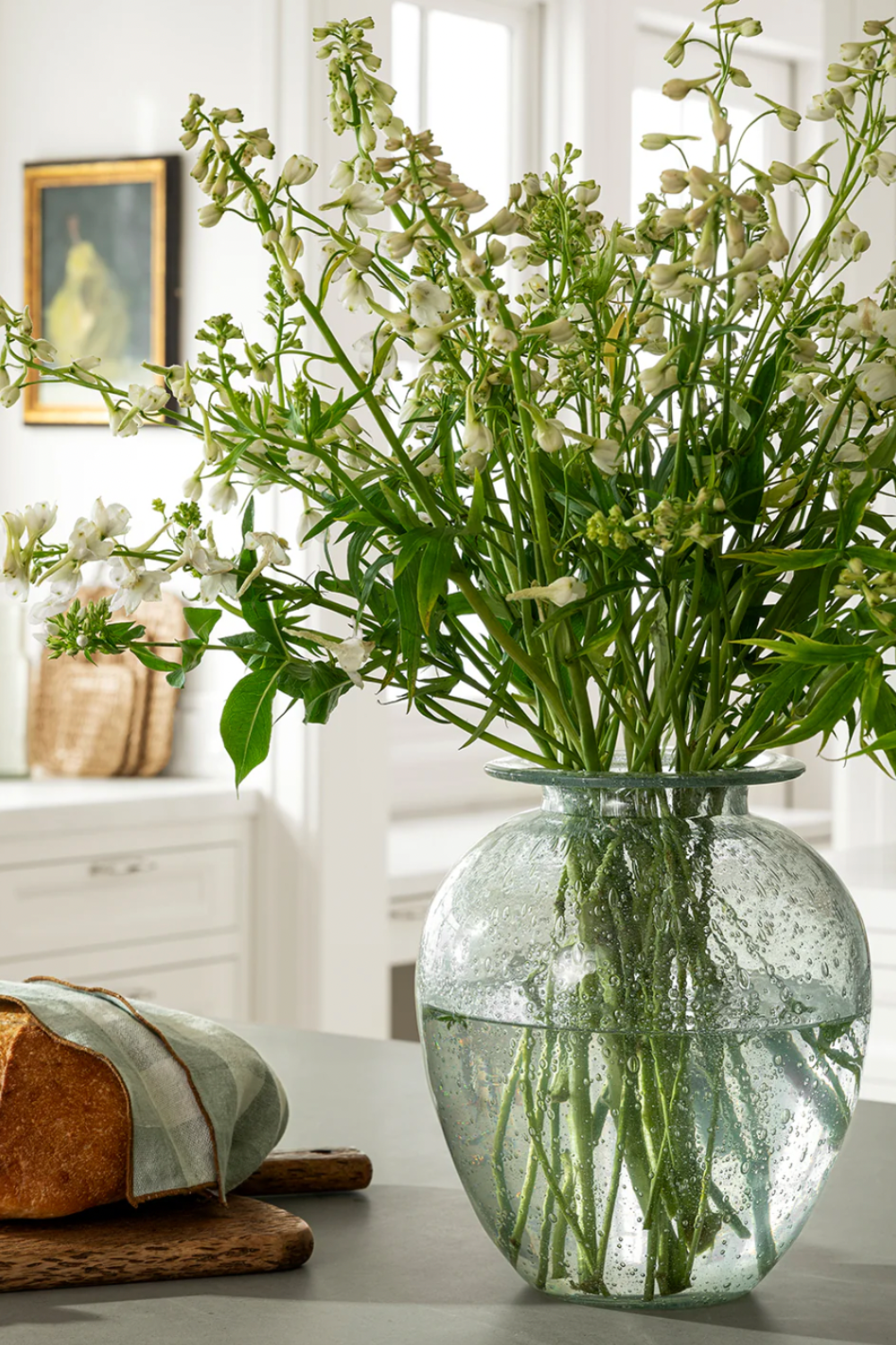 A rounded vase made from clear glass with textured bubbles throughout for a subtly vintage look.