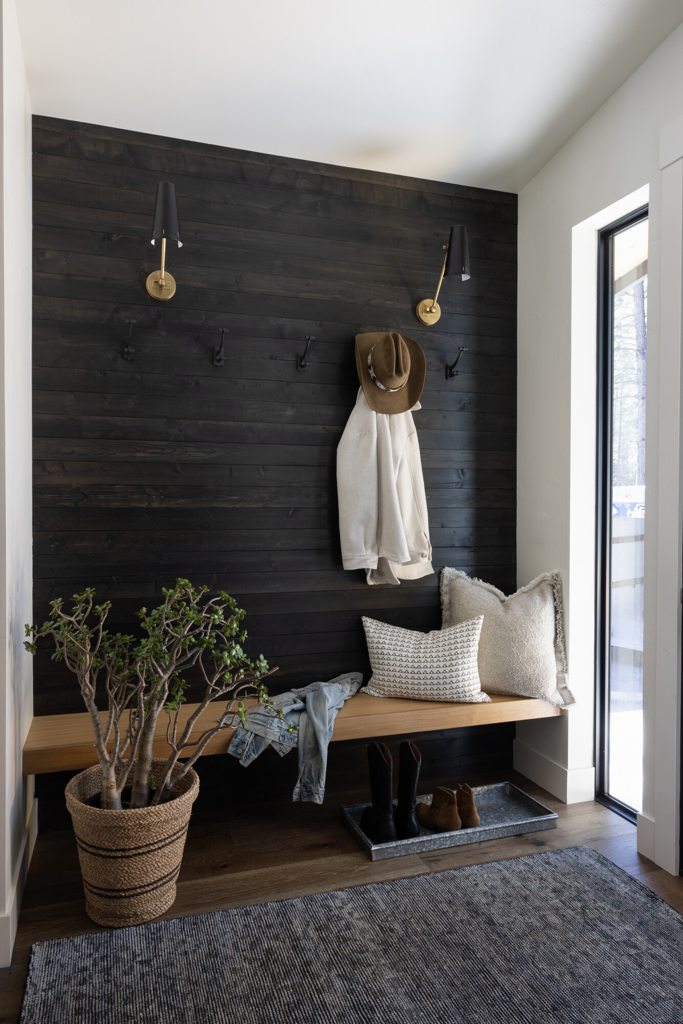 Entryway featuring vertical tongue and groove paneling in a neutral tone, paired with warm wood accents and natural textures.