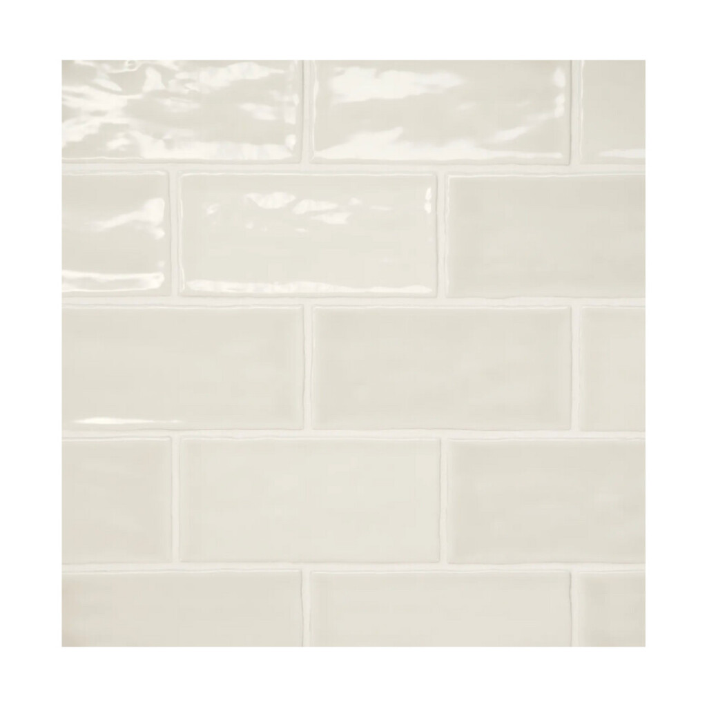Creamy off-white glossy subway tile, slightly wavy surface.