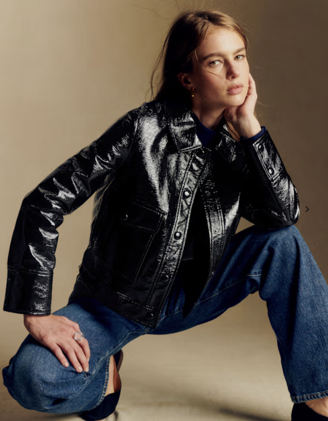 Glossy black leather jacket with buttons and patch pockets, modeled over jeans.