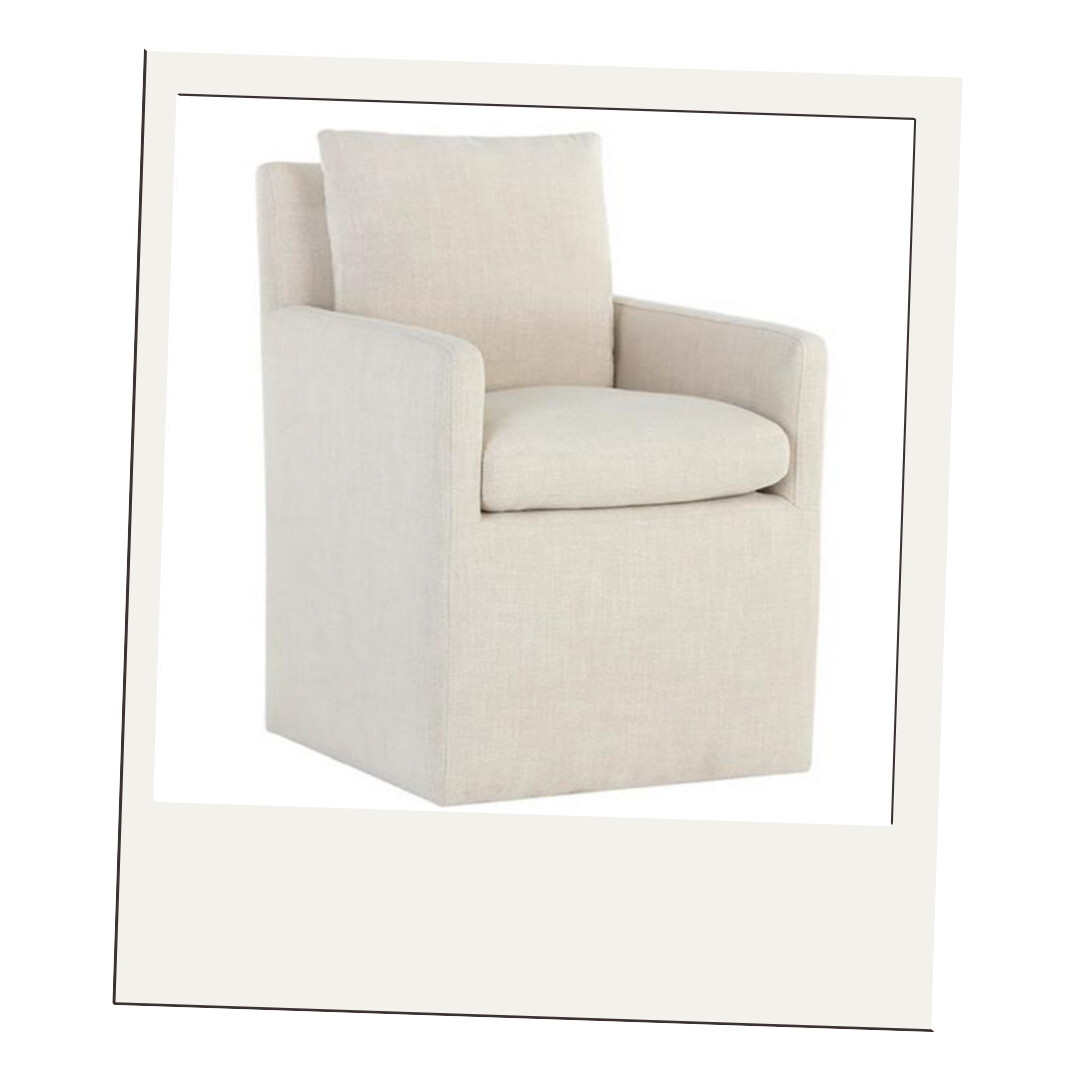 Cream upholstered swivel dining chair with boxy arms and soft linen texture, displayed against a neutral backdrop.