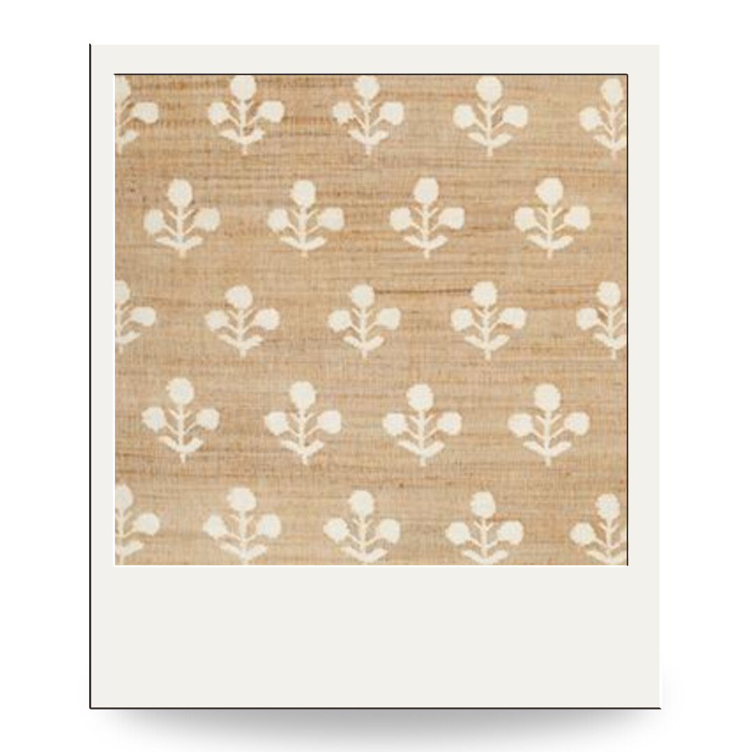 Natural jute area rug with an ivory block-printed floral motif, offering a warm, organic foundation for a dining room.