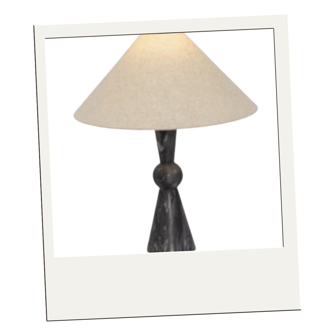 A black stone table lamp with a geometric base and a neutral linen shade, offering a sculptural yet organic touch.