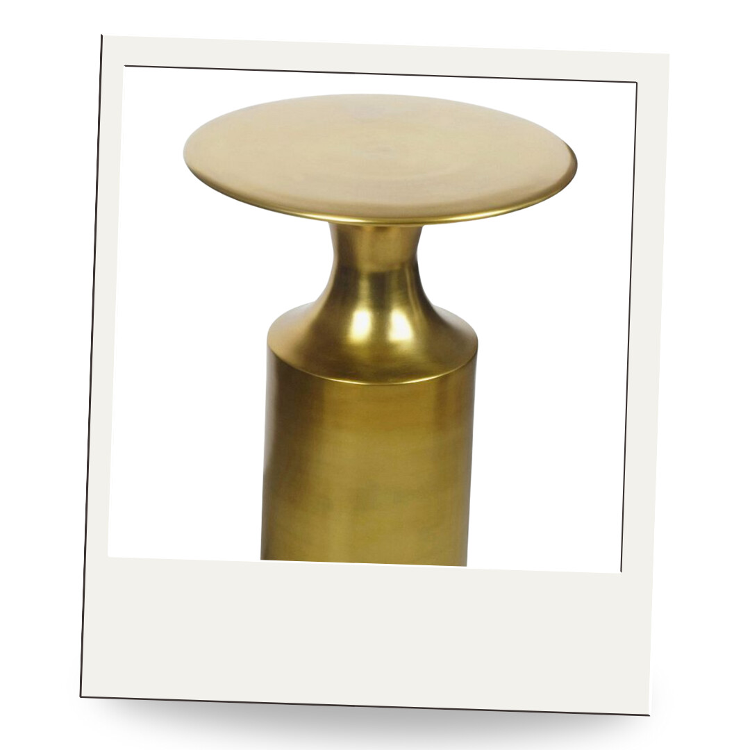 A modern brass side table with a sleek silhouette and warm metallic finish, perfect for layering beside a chair or sofa.