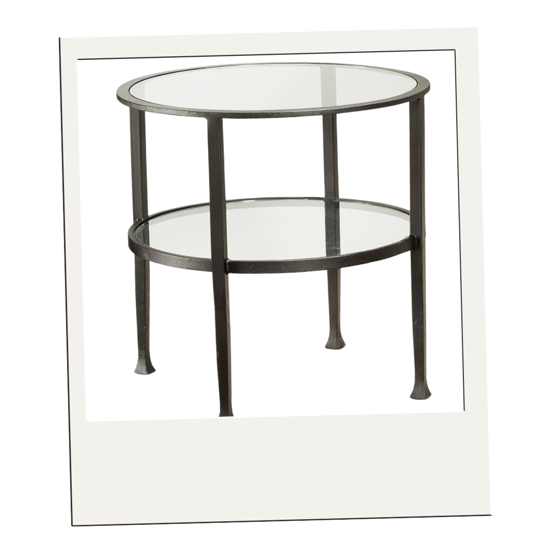 Two-tier round side table with blackened iron frame and glass shelves, ideal for bedside or sofa styling.