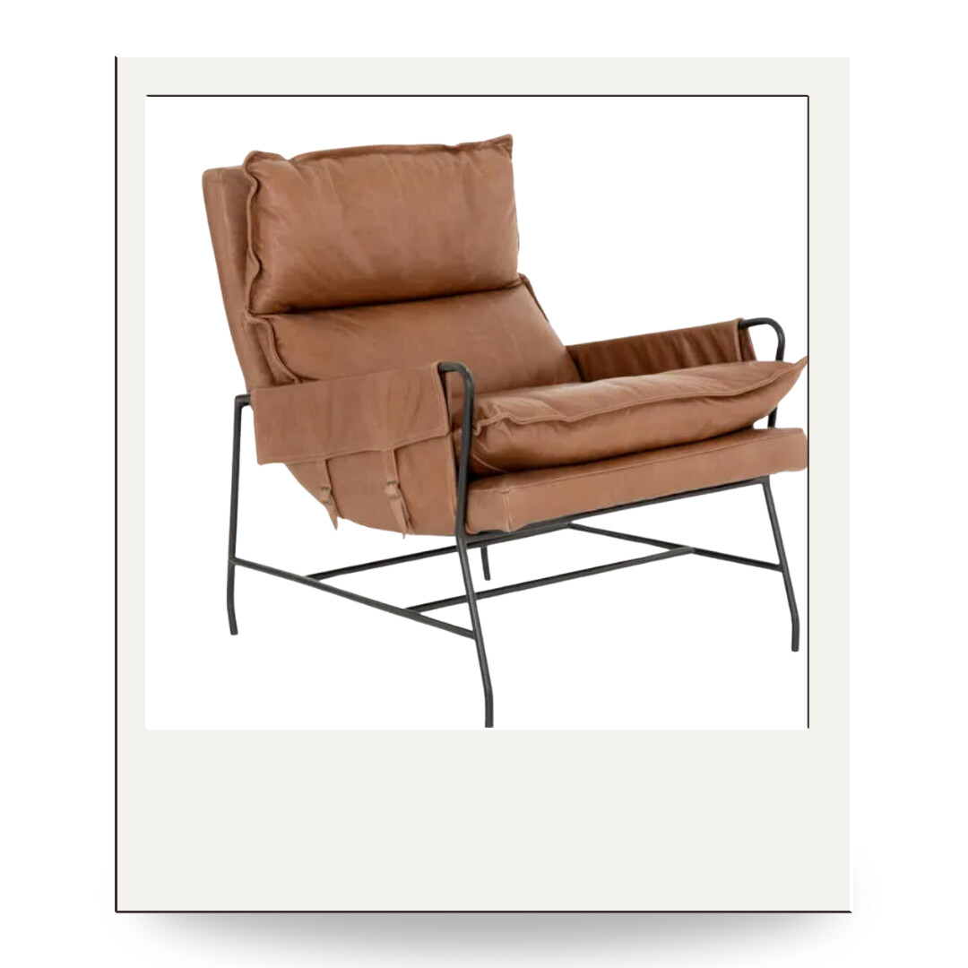 A caramel leather lounge chair with black iron frame and plush cushions, blending modern design with rustic comfort.
