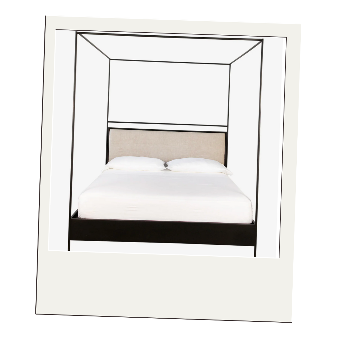 Modern black metal canopy bed with upholstered beige headboard and low platform base on a white backdrop.