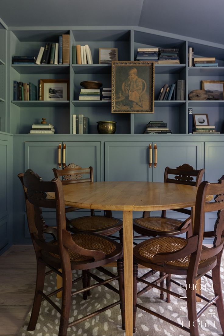 libarary/den room color drenched in a muted blue. Vintage furniture and a gallery/book wall.