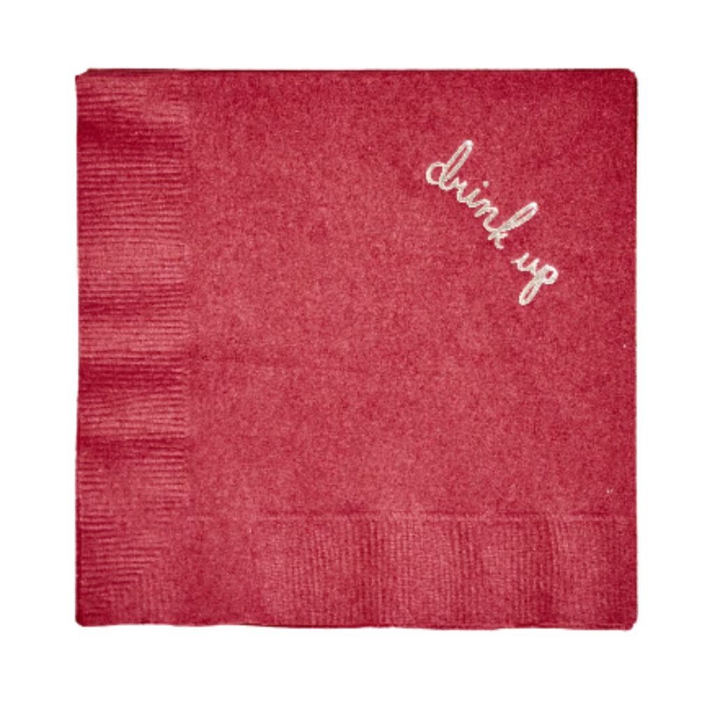 Deep red paper cocktail napkin embroidered with the words “drink up” in white script.