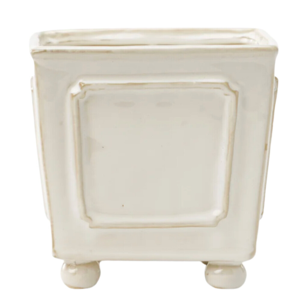 Small white ceramic planter with pedestal feet and subtle raised trim