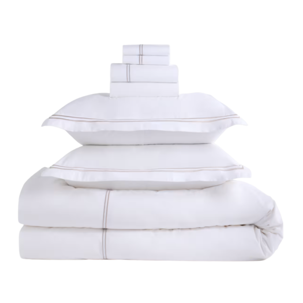 White bedding set with subtle embroidered trim and layered pillows