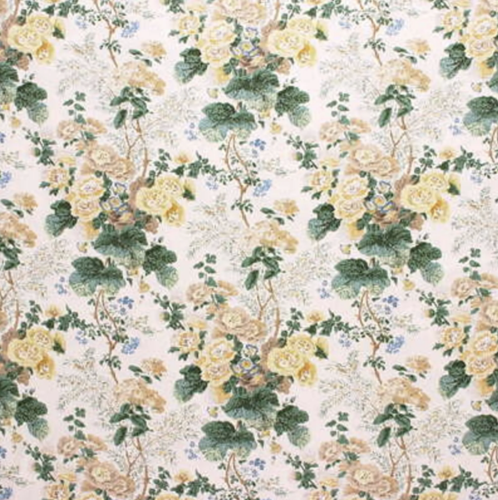 Soft, vintage-inspired floral fabric with yellow and cream blooms, leafy green accents, and delicate blue details on a warm neutral background.